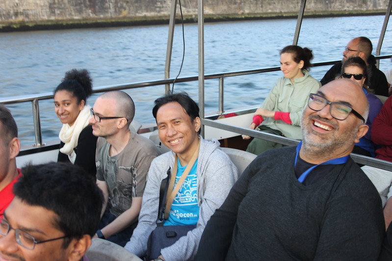DjangoCon Porto, on a boat, from left to right: Sarah, Tom, Sage and Daniel. We are all smiling and looking at the camera except Tom. 